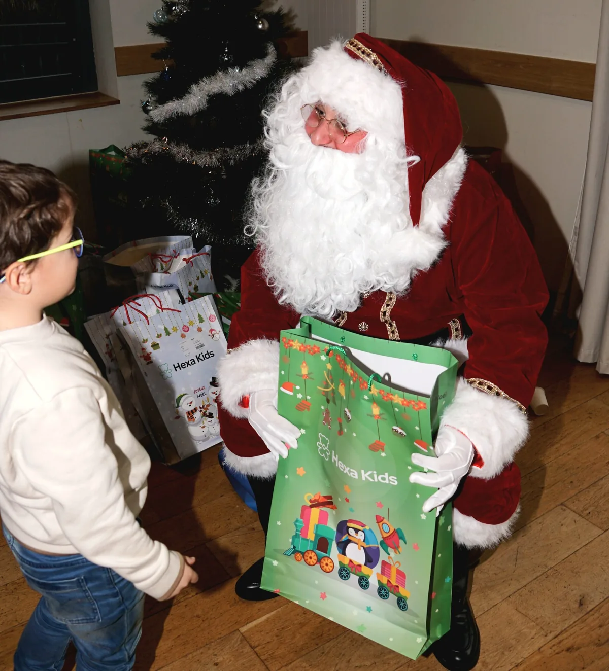 Le Père Noël remet un cadeau à un enfant lors d'une animation de fin d'année.