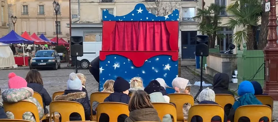 Public installé devant le théâtre ambulant aux couleurs du cirque.